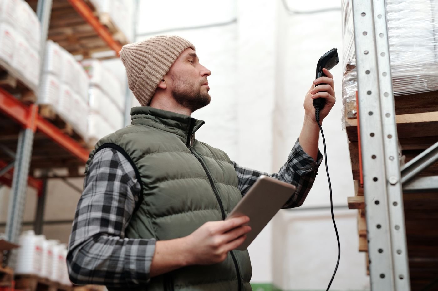 Préparateur scannant des produits avec une tablette dans l’entrepôt, projet WMS piloté en tant que Product Owner